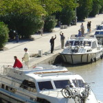 Patiently waiting our turn! Shoe and Pat on the quay wave to the captain's camera.